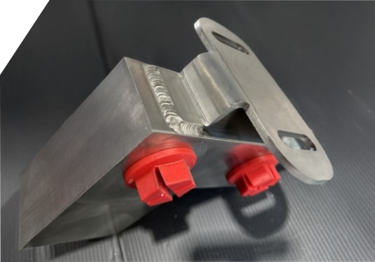 Pièce assemblée comprenant une zone soudée et des éléments plastiques