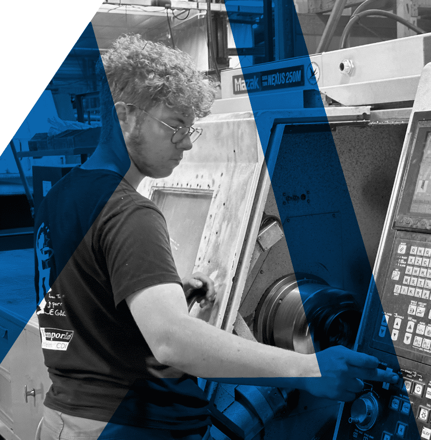 Opérateur en train de programmer une pièce sur un tour CN dans l'atelier d'AMG